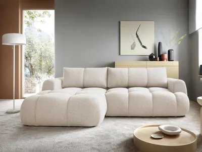 A modern living room with a sectional sofa, floor lamp, and artwork.