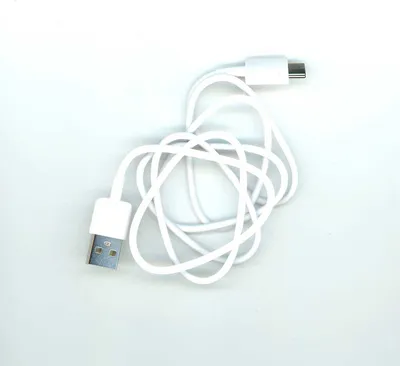 A white USB-C to USB-C charging cable is coiled on a white background.