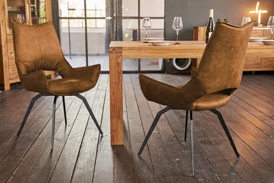 A dining room scene with two chairs and a wooden table.