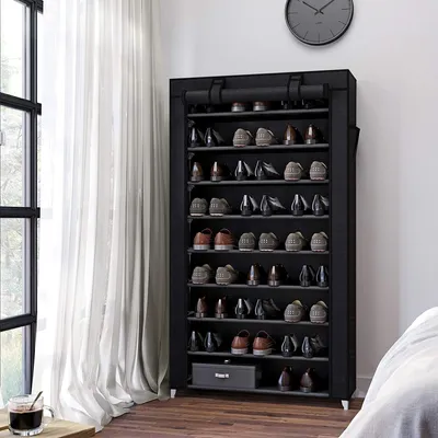 A shoe rack filled with shoes in a room with a window and curtains.