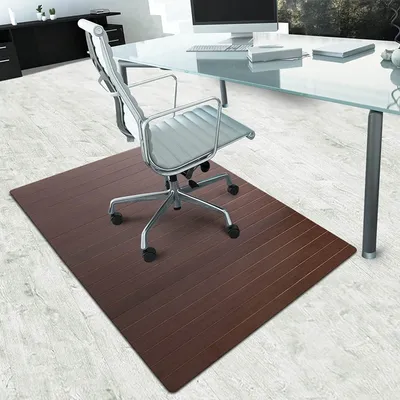 An office chair mat under an office chair in an office setting.