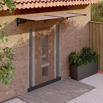 A door canopy is installed above a front door, with plants in a planter to the side.