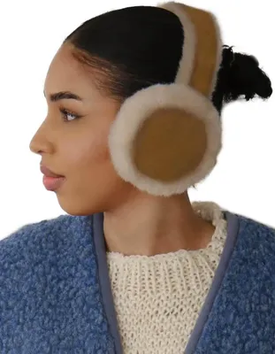 A woman wearing earmuffs and a sweater.