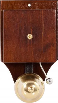 A retro-style doorbell made of wood and brass, mounted on a white background.