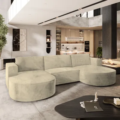 A modern living room with a large sectional sofa, kitchen in the background, and a fireplace.