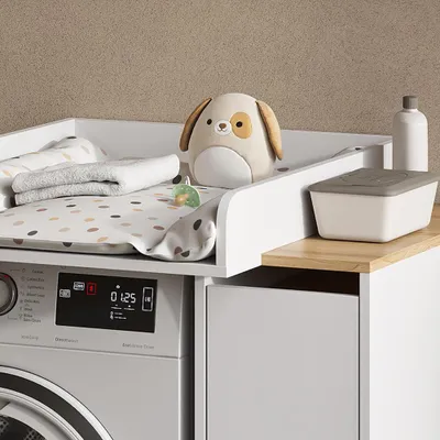 A baby changing station with a washing machine underneath.