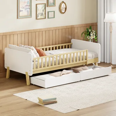 A child's bed with a pull-out trundle bed in a room with wood-paneled walls and framed pictures on the wall.
