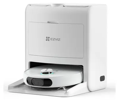 A white robot vacuum cleaner is docked in its charging station.