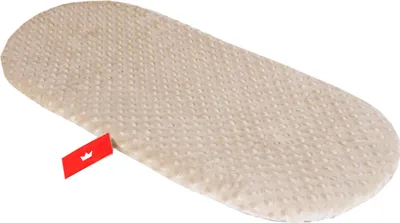 A beige oval-shaped mattress pad with a textured surface, lying on a white background. A small red tag with a white crown logo is attached to the left side of the pad.