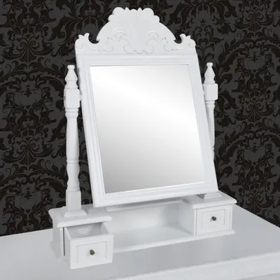 A white vanity table with a mirror and drawers against a dark patterned wallpaper.