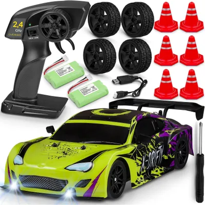 A collection of items for an RC car set, including the car, remote control, batteries, spare tires, and traffic cones.