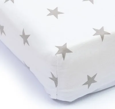 A close-up view of a white crib sheet with a gray star pattern.