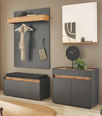 A modern entryway with a gray and wood tone furniture set, including a bench and a cabinet, with a coat rack and mirror.