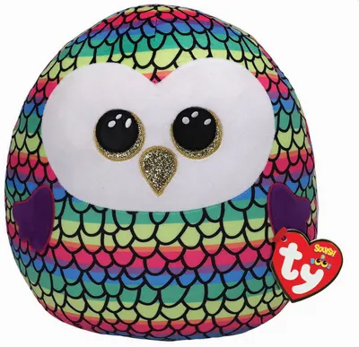 A colorful plush owl toy with large glittery eyes and a glittery beak, sitting on a white background. A red heart-shaped tag with the Ty logo is attached to its wing.