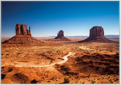 Produktbild von Wallario Wandbild Monument Valley unter blauem Himmel, Größe: 70,30 x 100,30 cm, Poster mit weißem Kunststoffrahmen