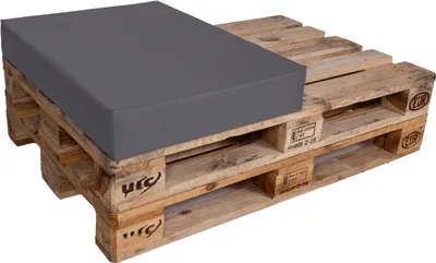 A gray cushion placed on a wooden pallet.