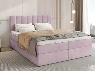 A pink upholstered bed with white bedding and a brown throw blanket, set in a modern bedroom with a textured wall and a large window.