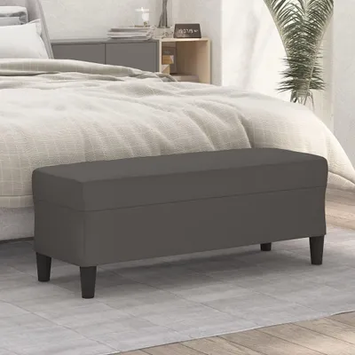 A gray bench is placed in front of a bed in a bedroom.