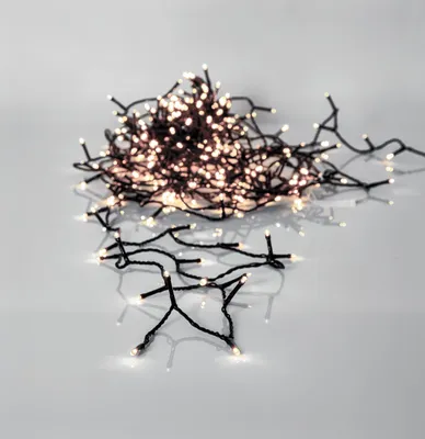 A pile of white LED string lights on a white and gray surface.