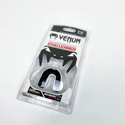 A Venum Challenger mouthguard is shown in its clear plastic packaging against a white background.