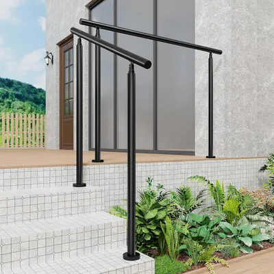A black metal handrail installed on outdoor stairs leading to a house entrance.