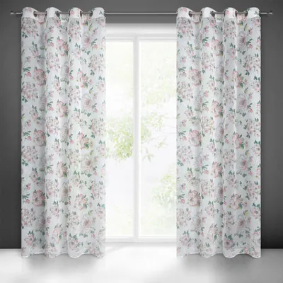 Two floral patterned curtains hanging in front of a window.