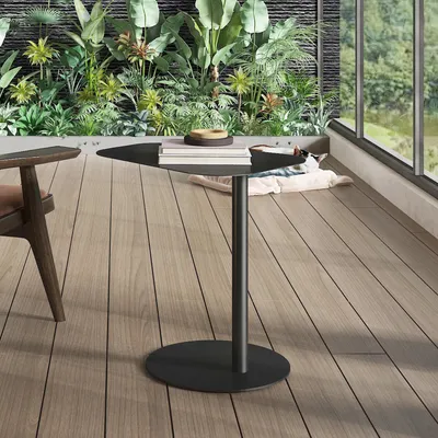 A modern balcony setting with lush plants and a view through a large window.