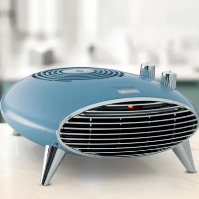 A blue retro-style fan heater with chrome legs and knobs, placed on a light-colored surface.