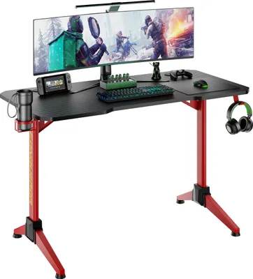 A gaming desk with a monitor, keyboard, mouse, and headphones.