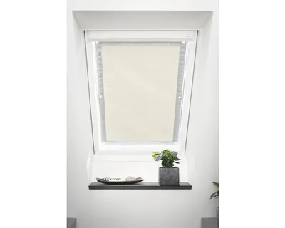 A skylight window with a beige roller blind installed.