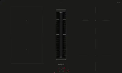 A top-down view of a black induction cooktop with an integrated ventilation system.