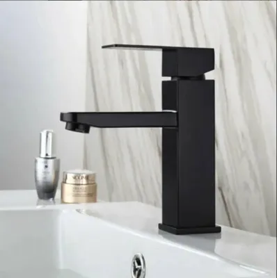 A black faucet is shown on a white sink with some cosmetic products next to it.