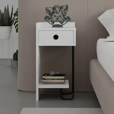 A white bedside table with a drawer and a shelf, next to a bed. There is a decorative dog figurine on top of the table.