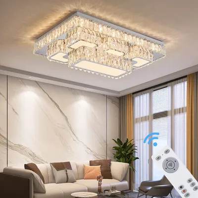 A modern living room with a sectional sofa, marble accent wall, and curtains, featuring a crystal ceiling light.