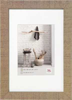 A framed picture of a rustic interior scene with a stool, basket, and branches.