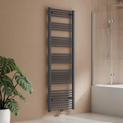 A grey towel radiator is shown in a bathroom setting next to a potted plant and a bathtub.