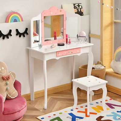 A child's play vanity set with a chair in a room with decorative wall art and a rug.