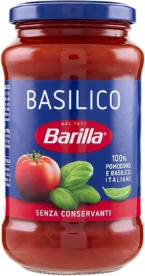 A jar of Barilla basil sauce against a white background.