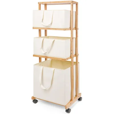 A three-tiered bamboo laundry basket with beige fabric bins on a white background.