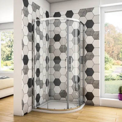 A modern bathroom with a hexagonal tiled wall and a glass shower enclosure.