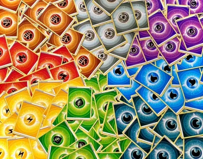 A pile of Pokemon energy cards, sorted by type and color, forming a rainbow effect.