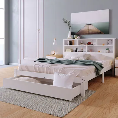 A white bed with a bookshelf headboard and a pull-out drawer in a bedroom.