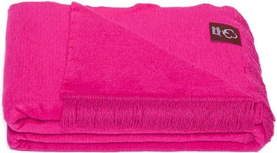 A folded fuchsia blanket with fringe on a white background.