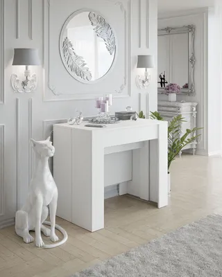 A white console table with decorative items and a cat statue in a well-lit room.