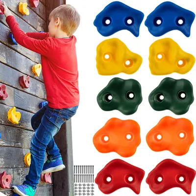 A child climbing a wall with colorful climbing holds.