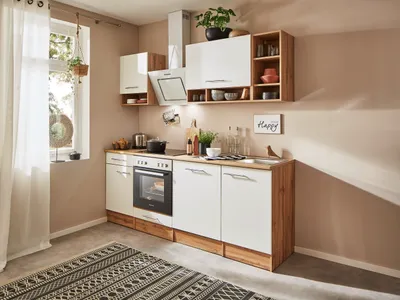 A modern kitchen setup with white cabinets and wood accents, featuring appliances and decor.