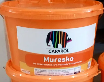 A close-up shot of an orange bucket of paint with a label.