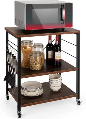 A three-tier kitchen cart with a microwave on top and various kitchen items on the shelves.