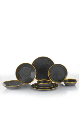 A collection of black ceramic plates and bowls with gold trim, arranged on a white background.