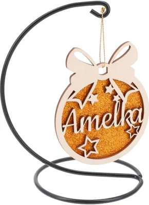 A wooden Christmas ornament with the name 'Amelka' and glittery stars, hanging from a black metal stand.